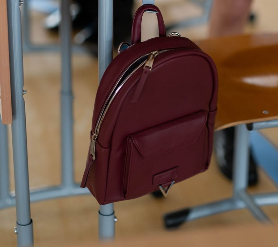 Mochila escolar bem conservada ao lado de uma carteira